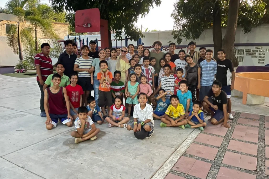 Large group of children and adults posing together outdoors.