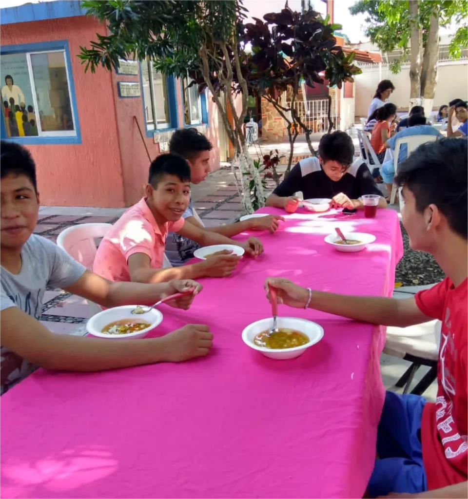 Teenagers enjoying a meal together outdoors.