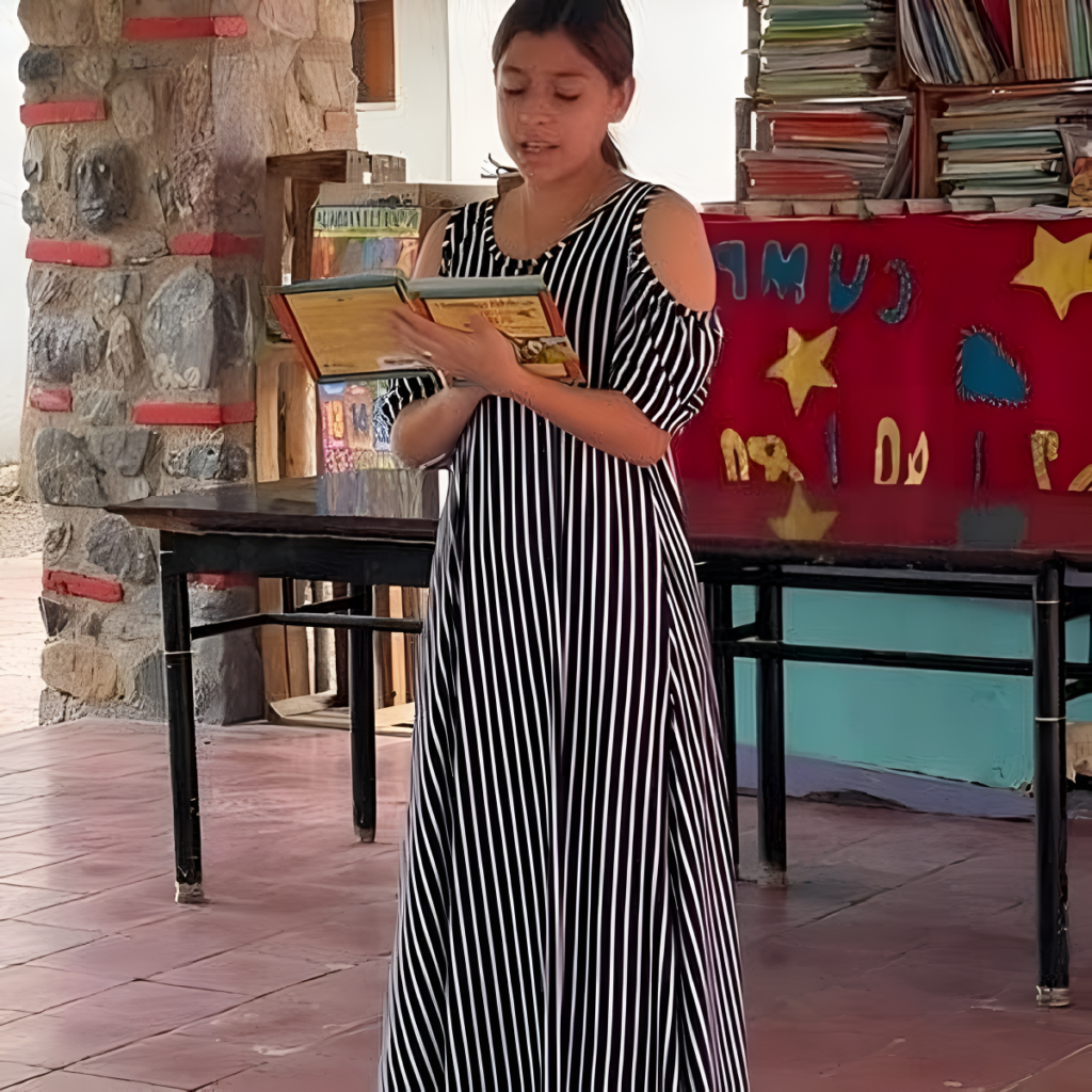 Young woman reading a storybook in a library setting with colorful decorations in the background.